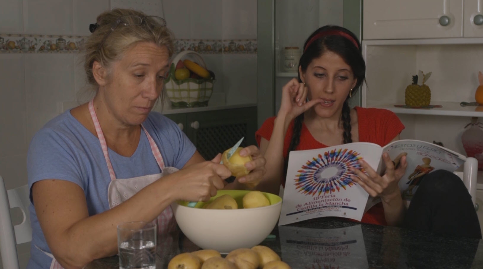Dos mujeres en una cocina preparando comida en una escena cotidiana