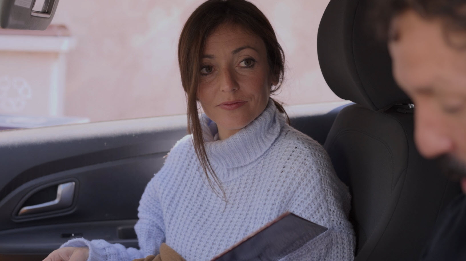 Mujer sentada en un coche durante una escena de conversación